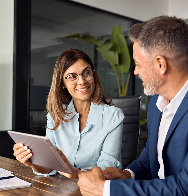 Two colleagues of professional business people working on tablet.